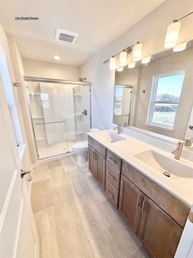 bathroom featuring toilet, vanity, and walk in shower