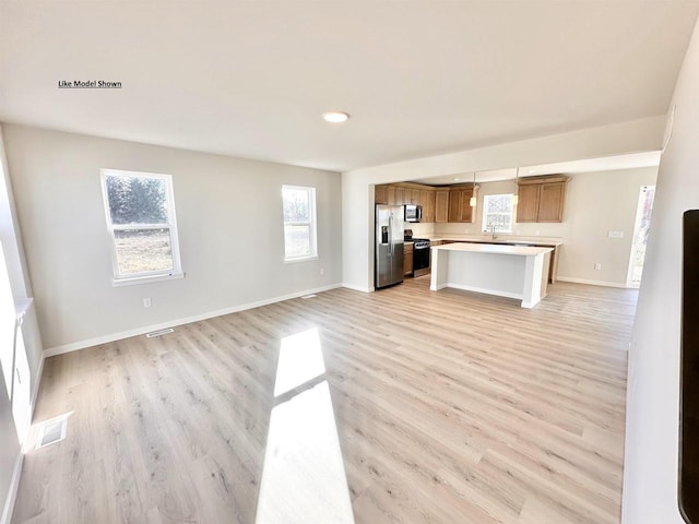 kitchen with sink, stainless steel appliances, and light hardwood / wood-style floors