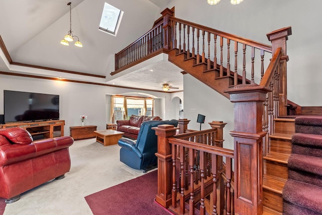 carpeted living room with crown molding, ceiling fan with notable chandelier, and lofted ceiling