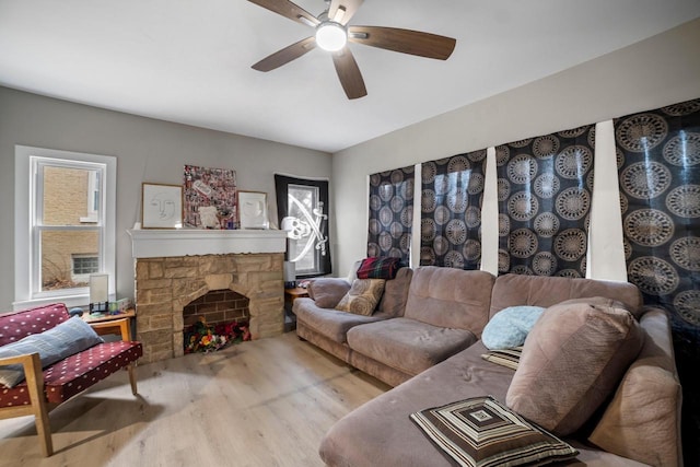 living room featuring ceiling fan, wood-type flooring, and a fireplace