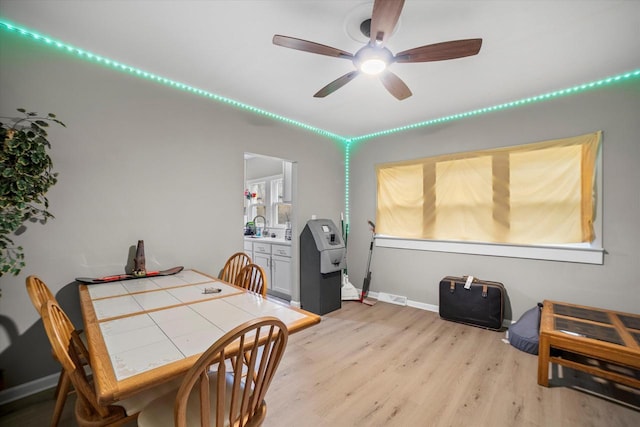 dining space featuring light hardwood / wood-style floors, ceiling fan, and sink