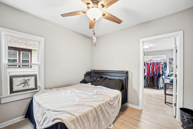 bedroom featuring multiple windows, ceiling fan, a closet, and light hardwood / wood-style floors