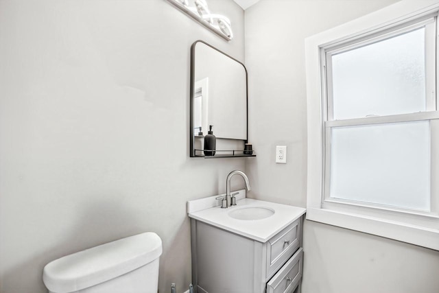 bathroom with vanity, toilet, and a wealth of natural light