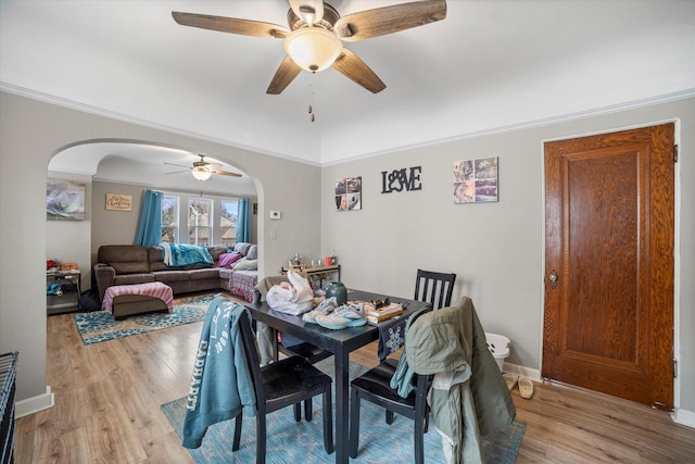 dining room featuring light wood-type flooring, ceiling fan, and crown molding