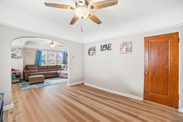 living room with crown molding, ceiling fan, and light hardwood / wood-style floors