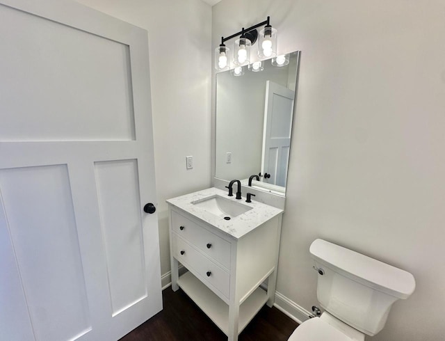 bathroom featuring wood-type flooring, vanity, and toilet