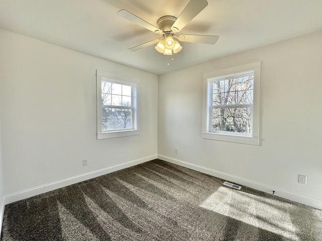 carpeted spare room with a wealth of natural light and ceiling fan