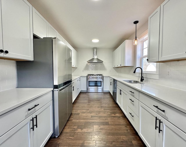 kitchen with white cabinetry, wall chimney range hood, sink, and appliances with stainless steel finishes