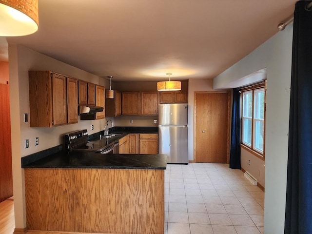 kitchen featuring pendant lighting, stove, sink, kitchen peninsula, and stainless steel refrigerator