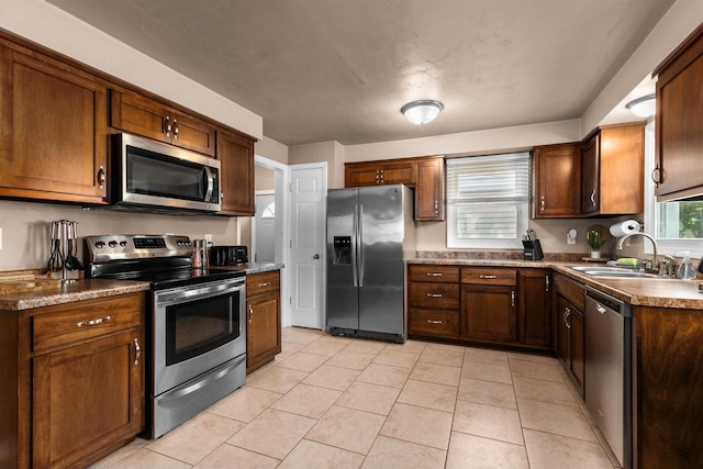 kitchen with sink, light tile patterned floors, and stainless steel appliances