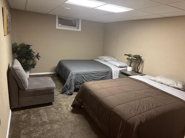 carpeted bedroom featuring a drop ceiling