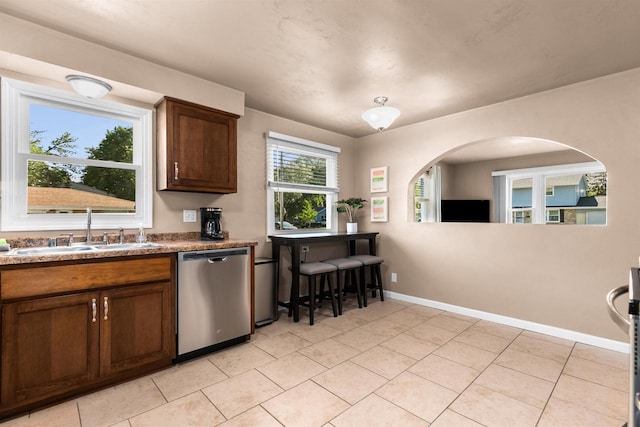 kitchen featuring sink, light tile patterned floors, and stainless steel dishwasher