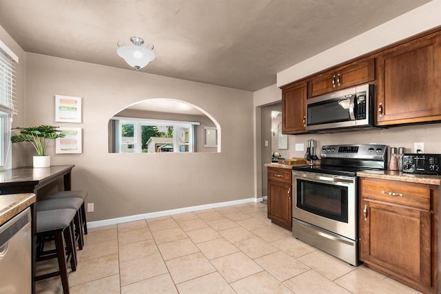 kitchen featuring light tile patterned flooring and stainless steel appliances