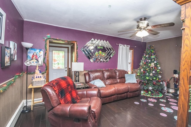 living room with baseboard heating, ceiling fan, dark wood-type flooring, and ornamental molding