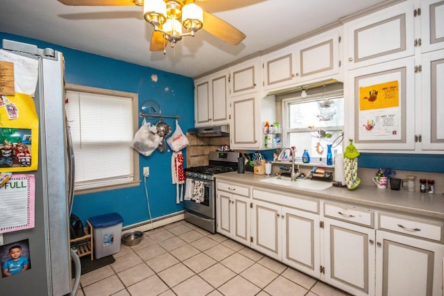 kitchen with white cabinets, sink, light tile patterned floors, appliances with stainless steel finishes, and a baseboard radiator