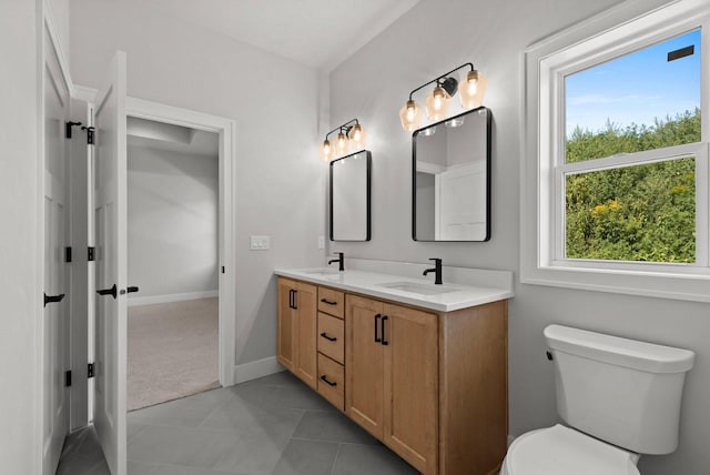 bathroom with tile patterned flooring, vanity, and toilet