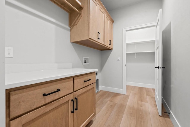 clothes washing area with cabinets, washer hookup, light wood-type flooring, and electric dryer hookup