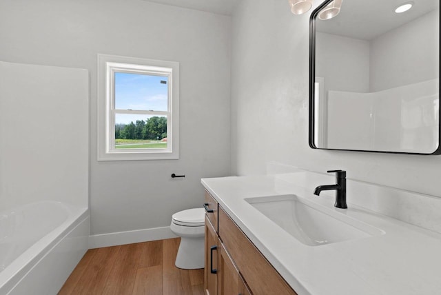 full bathroom featuring wood-type flooring, vanity, bathing tub / shower combination, and toilet