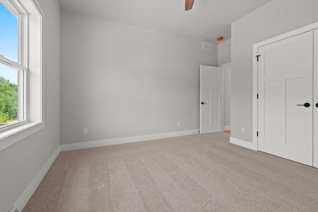 carpeted spare room with ceiling fan