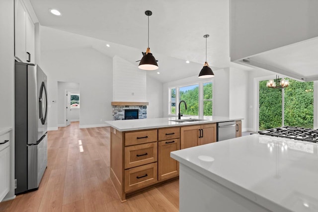 kitchen featuring sink, pendant lighting, a kitchen island with sink, white cabinets, and appliances with stainless steel finishes