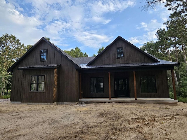 view of front of property featuring a porch, metal roof, a standing seam roof, and a shingled roof