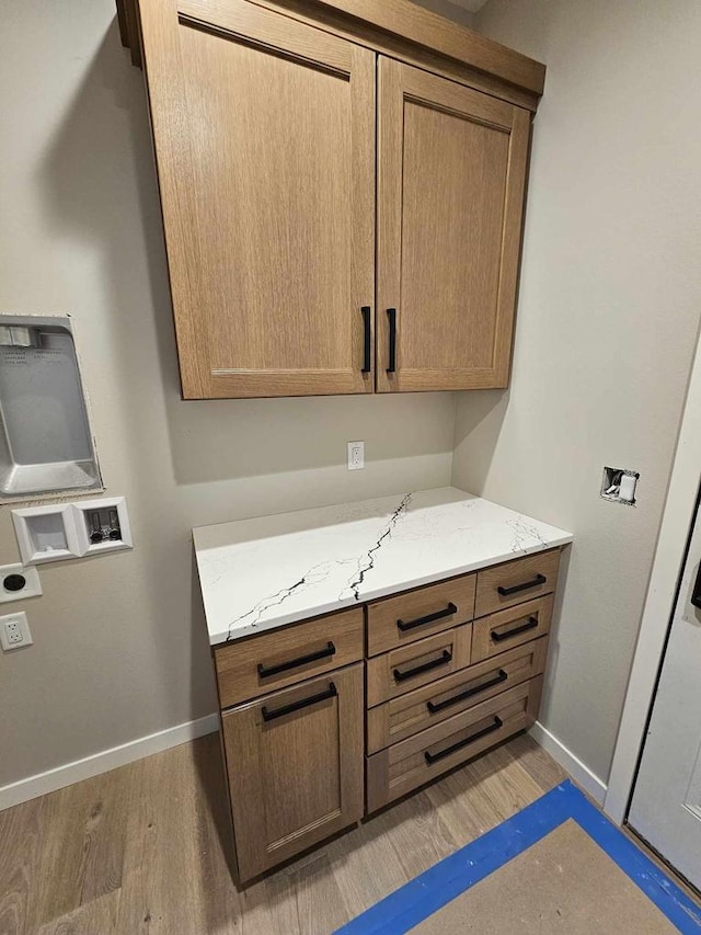 laundry area featuring washer hookup, cabinets, and light wood-type flooring