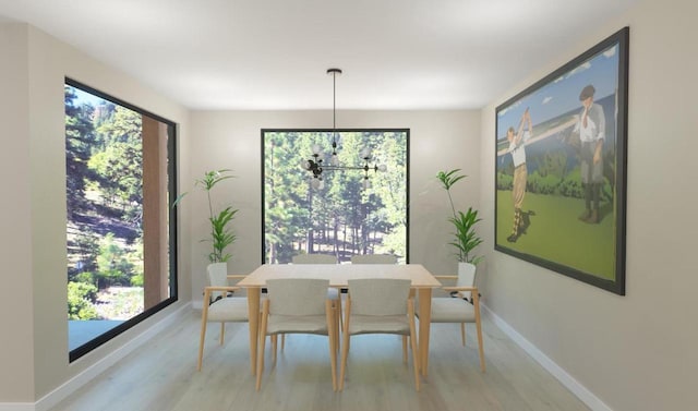 dining space with baseboards and light wood-style flooring