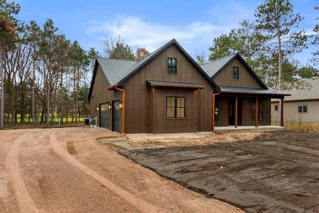 view of front of property with a garage, covered porch, and central air condition unit