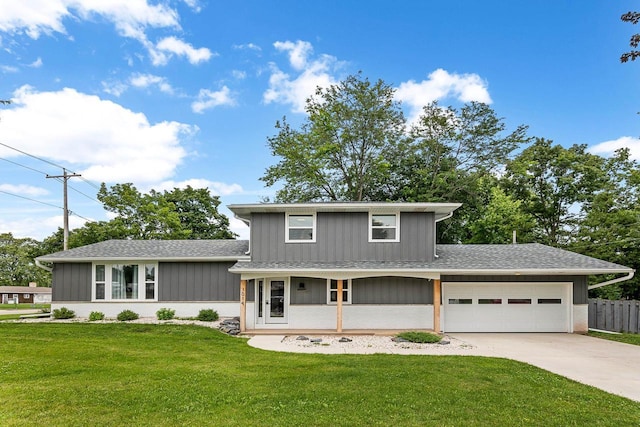 view of front of house featuring a front yard, a porch, and a garage