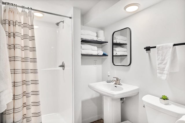 bathroom featuring a shower with curtain and toilet