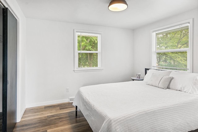 bedroom with dark hardwood / wood-style floors