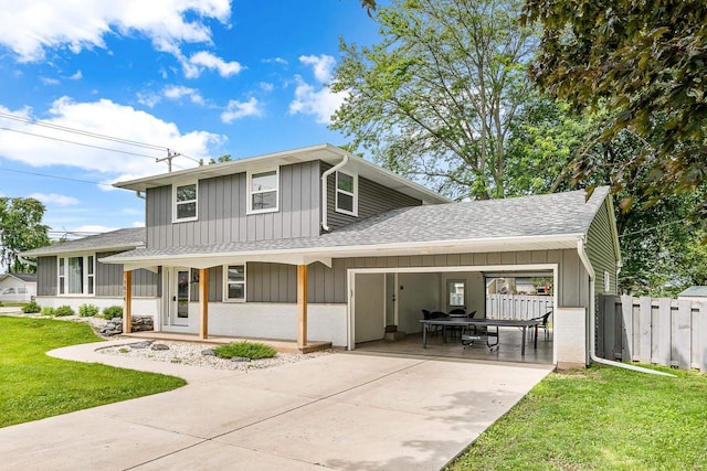 rear view of house featuring a lawn, a porch, and a carport