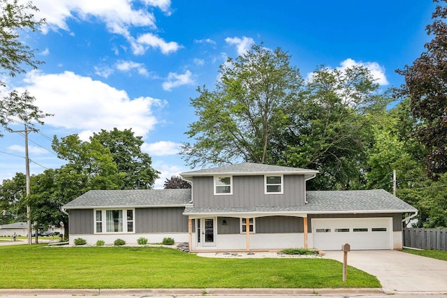 split level home featuring a porch, a front yard, and a garage