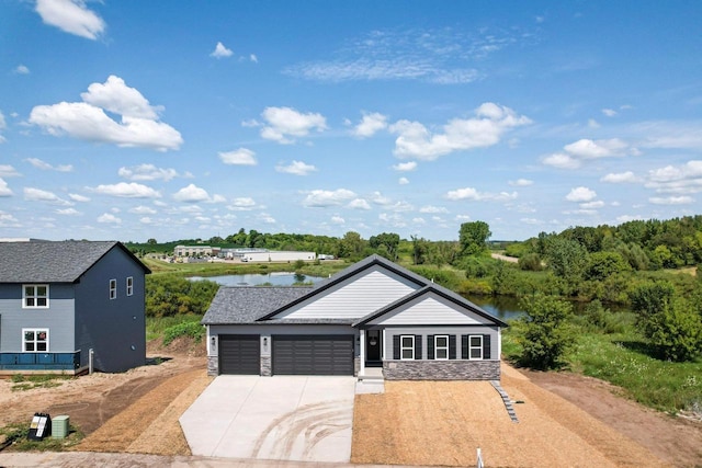 single story home featuring a garage and a water view