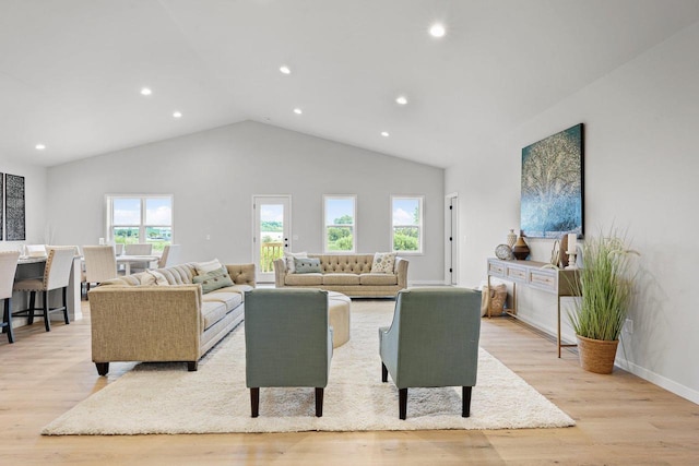 living room featuring high vaulted ceiling and light hardwood / wood-style floors