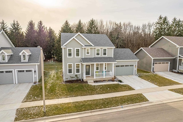 view of front of house with a porch, a yard, and a garage