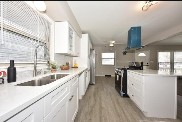 kitchen with backsplash, white cabinets, sink, black range with electric cooktop, and island exhaust hood