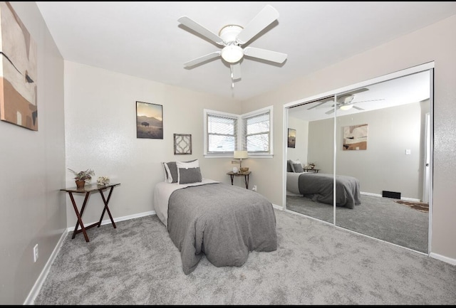 carpeted bedroom featuring ceiling fan and a closet