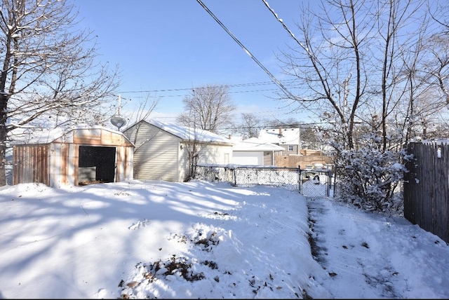 snowy yard featuring a shed