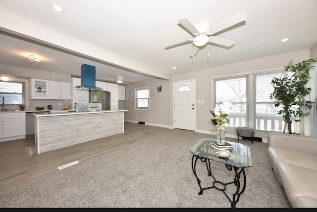 living room featuring hardwood / wood-style floors, ceiling fan, and sink