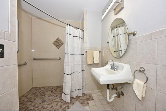 bathroom with a shower with shower curtain, tile walls, and sink