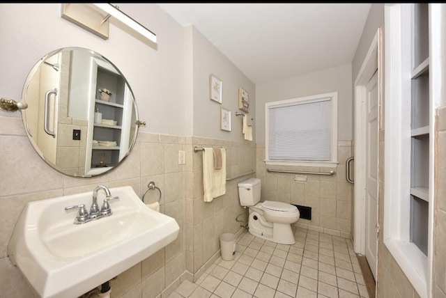 bathroom with tile patterned flooring, sink, toilet, and tile walls