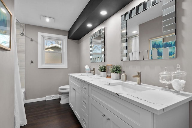 full bathroom with shower / bathtub combination with curtain, hardwood / wood-style flooring, vanity, and toilet