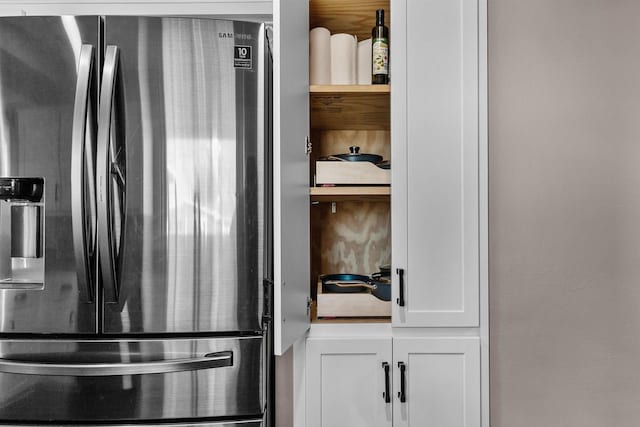 kitchen featuring white cabinets and stainless steel fridge with ice dispenser