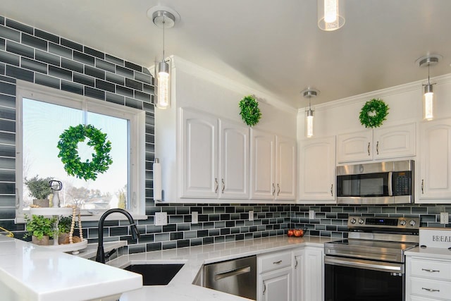 kitchen featuring pendant lighting, white cabinetry, and stainless steel appliances