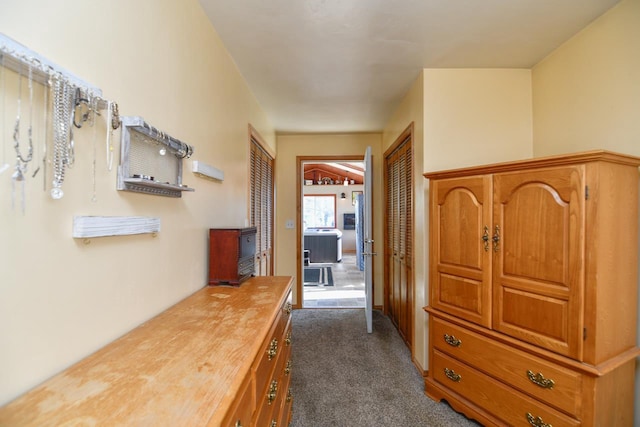 hallway featuring dark colored carpet