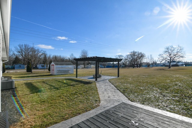 view of yard with a storage shed, a pergola, a deck, and central air condition unit