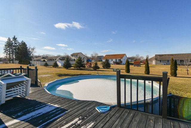 view of swimming pool with a yard and a wooden deck