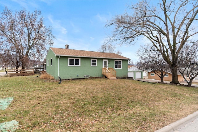 rear view of house featuring a lawn and a garage