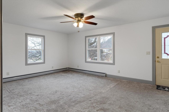 carpeted empty room featuring ceiling fan, a healthy amount of sunlight, and a baseboard radiator